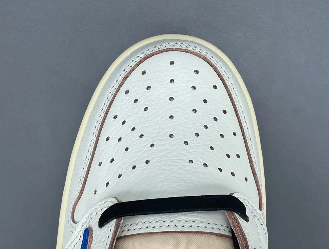 Air Jordan 1 Low OG x Travis Scott x Fragment with a white, black, and blue design, reverse Swoosh, and co-branded heel logos.