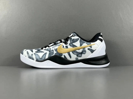 Basketball shoe with camouflage pattern and gold Nike logo on a gray background