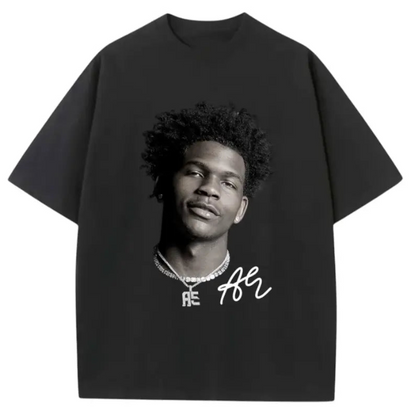A black oversized short-sleeve t-shirt featuring a black-and-white graphic print of a man's portrait on the front, with a white signature-style graphic and jewelry detail below.
