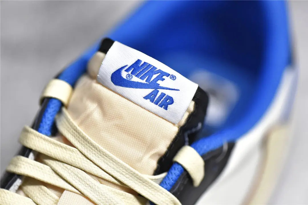 "Air Jordan 1 Low Travis Scott x Fragment – Iconic sneaker featuring a mix of white, blue, and black leather with Travis Scott’s signature reverse Swoosh and Fragment branding."