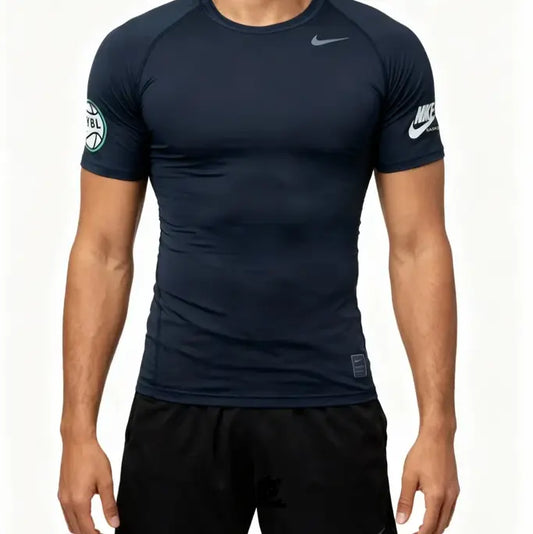 A man wearing a dark navy blue Nike athletic compression shirt with white logos on the chest and sleeve, paired with black shorts, against a plain white background.
