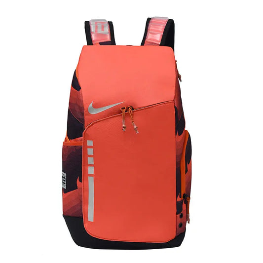 A Nike backpack in a vibrant orange and black colorway, featuring a prominent silver Nike swoosh on the front pocket, reflective silver vertical stripes, and orange-and-black patterned side panels.