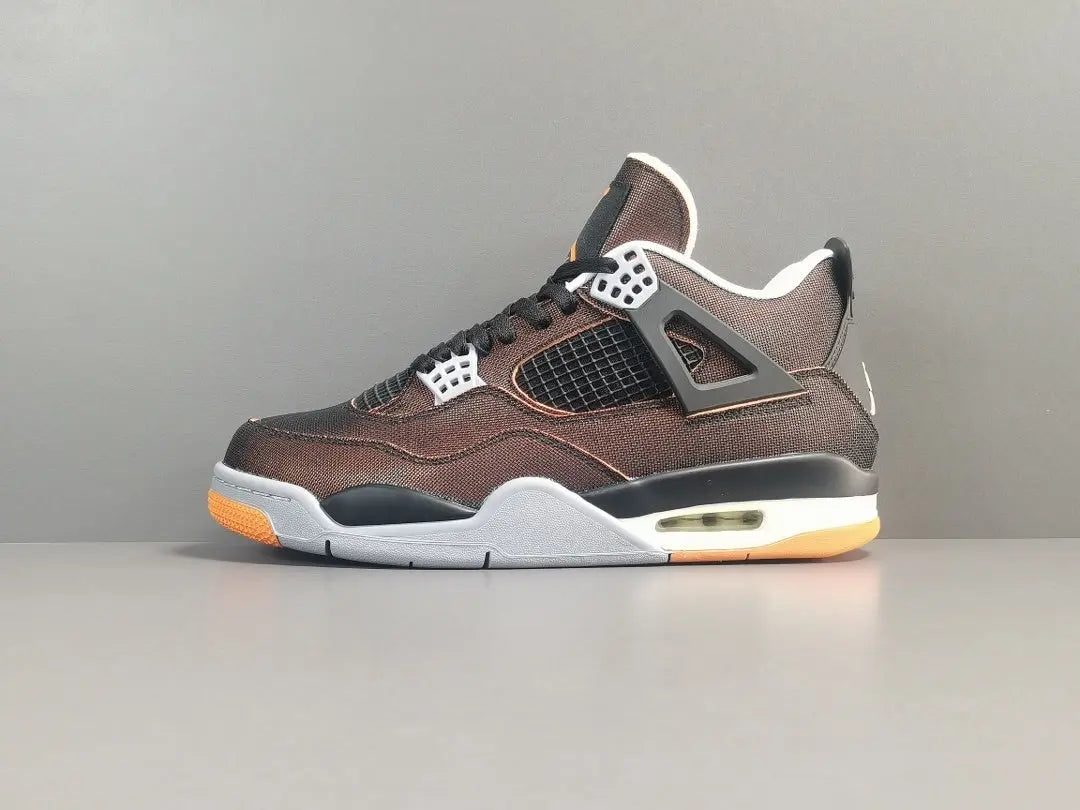 Brown sneaker with orange sole on a gray background