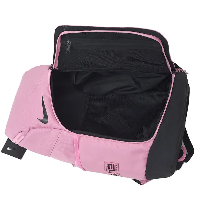 A pink and black Nike duffel bag shown open against a white background, displaying its interior compartments and the black Nike swoosh logo on the side.