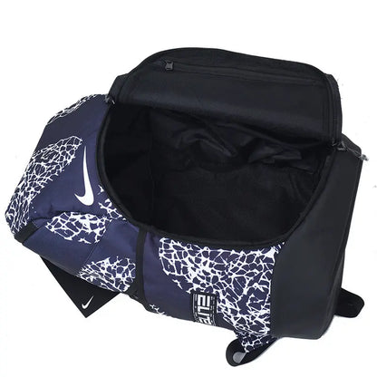 A Nike duffel bag in navy blue and white with a cracked pattern, shown open to display its black interior. The bag features a white Nike swoosh on the side and a black-and-white striped logo patch on the front.
