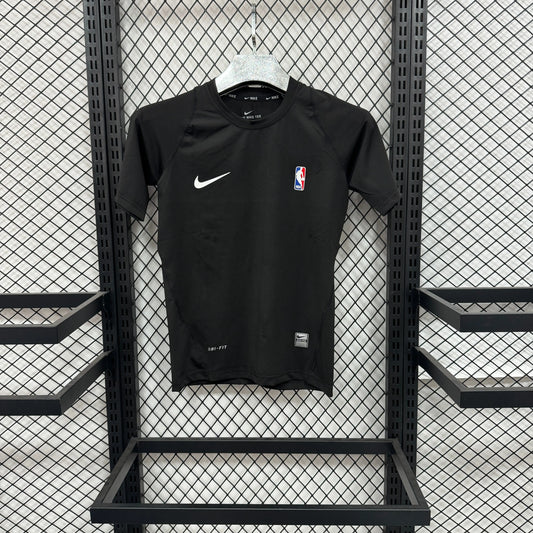 A black Nike short-sleeve athletic t-shirt with a white swoosh and NBA logo, hanging on a white hanger against a black metal mesh display rack.
