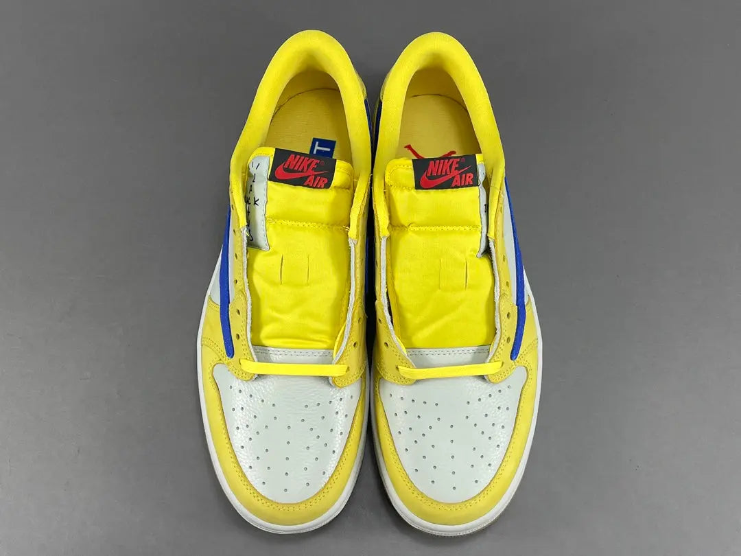"Jordan 1 Low OG x Canary – low-top sneaker with premium leather upper, bright yellow and white colorway, and classic retro design."