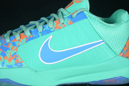 A close-up of a Nike athletic shoe in mint green, light blue, and orange, showing the side profile with the Nike Swoosh logo.