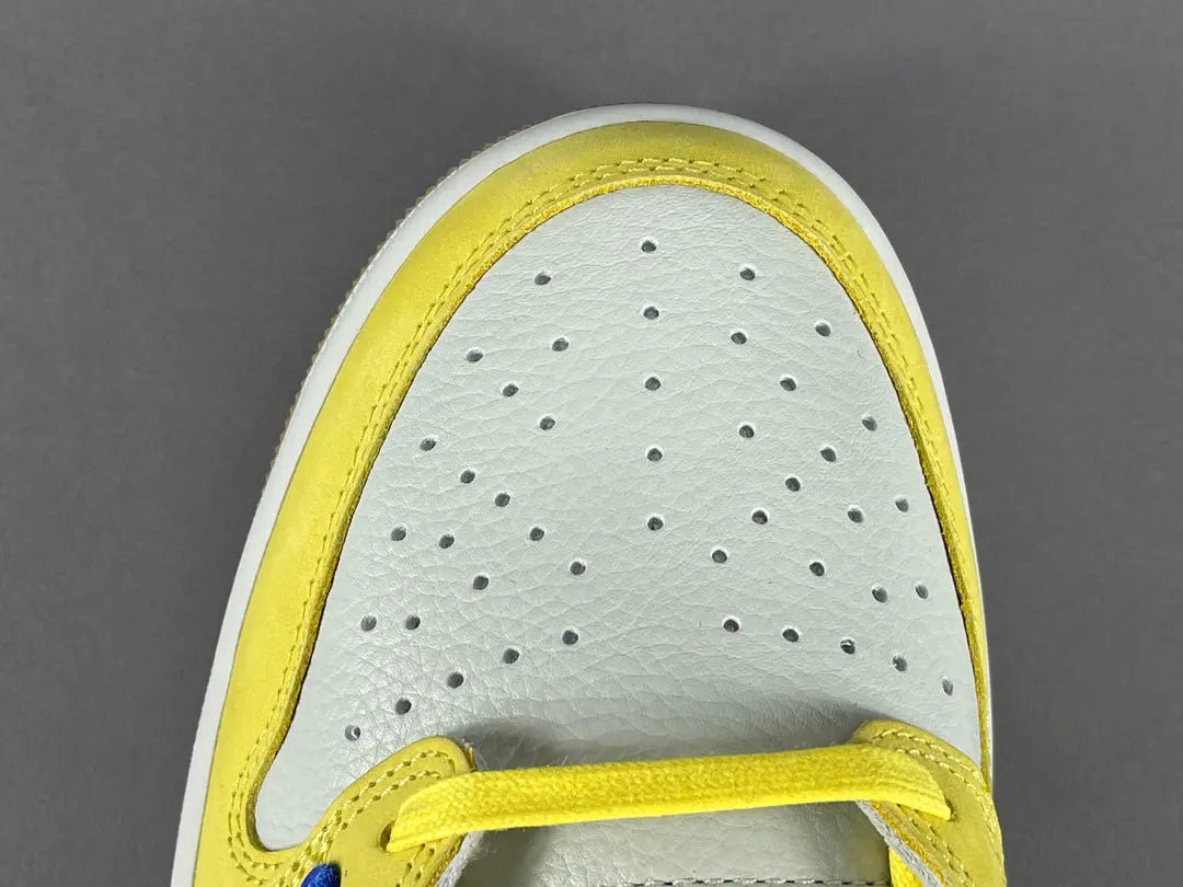 "Jordan 1 Low OG x Canary – low-top sneaker with premium leather upper, bright yellow and white colorway, and classic retro design."