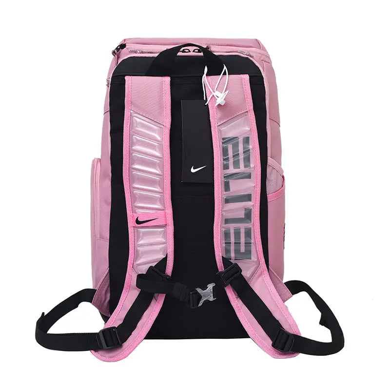Pink and black Nike backpack shown from the back, featuring padded shoulder straps, a black hangtag, and reflective vertical text on the back panel.