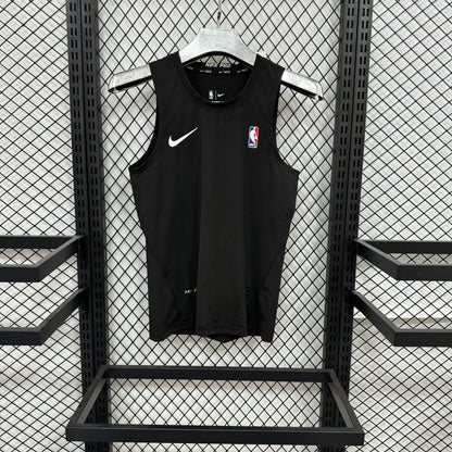 A black Nike sleeveless basketball jersey with a white swoosh and an NBA logo on the chest, hanging on a white hanger against a black metal mesh display wall.