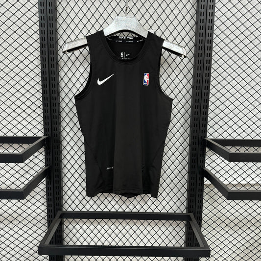 A black Nike sleeveless basketball jersey with a white swoosh and an NBA logo on the chest, hanging on a white hanger against a black metal mesh display wall.