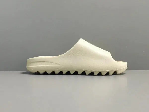 "adidas Yeezy Slide x Bone – sleek beige slide with soft EVA foam, minimalist design, and ridged outsole for comfort and traction."