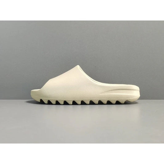 "adidas Yeezy Slide x Bone – sleek beige slide with soft EVA foam, minimalist design, and ridged outsole for comfort and traction."