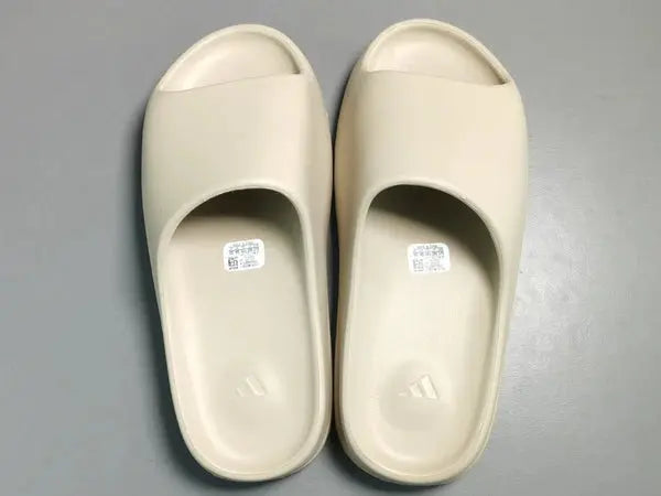 "adidas Yeezy Slide x Bone – sleek beige slide with soft EVA foam, minimalist design, and ridged outsole for comfort and traction."