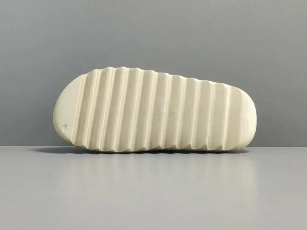 "adidas Yeezy Slide x Bone – sleek beige slide with soft EVA foam, minimalist design, and ridged outsole for comfort and traction."