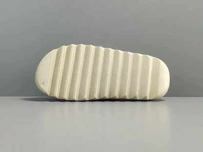 "adidas Yeezy Slide x Bone – sleek beige slide with soft EVA foam, minimalist design, and ridged outsole for comfort and traction."