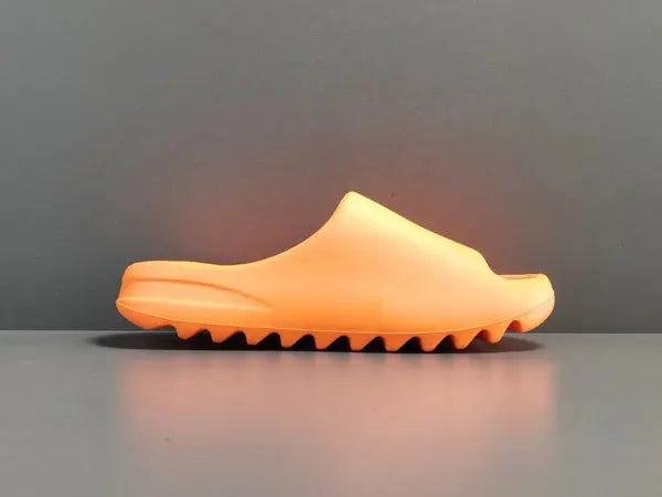 "adidas Yeezy Slide x Enflame Orange – vibrant orange slide with soft EVA foam, minimalist design, and ridged outsole for comfort and traction."