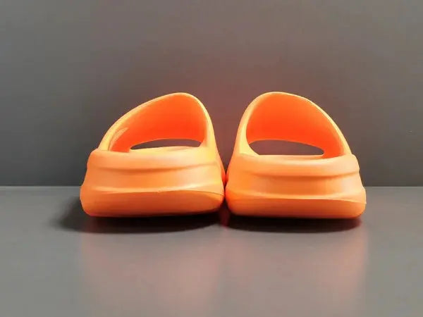 "adidas Yeezy Slide x Enflame Orange – vibrant orange slide with soft EVA foam, minimalist design, and ridged outsole for comfort and traction."