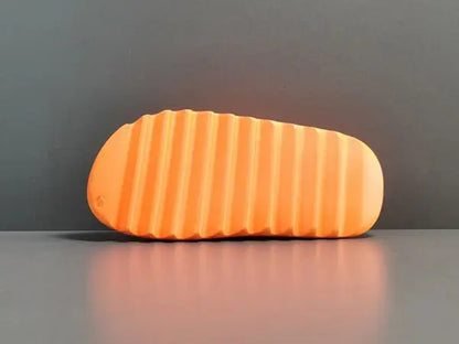 "adidas Yeezy Slide x Enflame Orange – vibrant orange slide with soft EVA foam, minimalist design, and ridged outsole for comfort and traction."