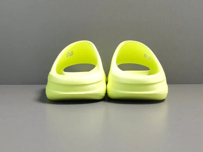 "adidas Yeezy Slide x Glow Green – vibrant neon-green slide with soft EVA foam, minimalist design, and ridged outsole for comfort and traction."
