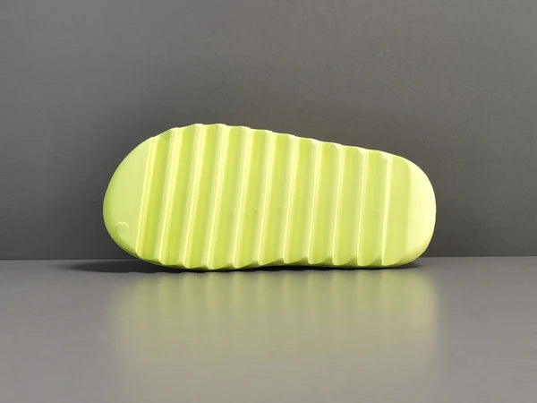 "adidas Yeezy Slide x Glow Green – vibrant neon-green slide with soft EVA foam, minimalist design, and ridged outsole for comfort and traction."