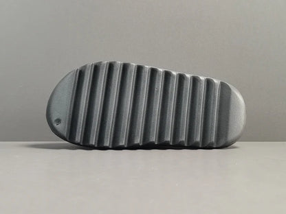 "adidas Yeezy Slide x Onyx – sleek all-black slide with soft EVA foam, minimalist design, and ridged outsole for comfort and grip."