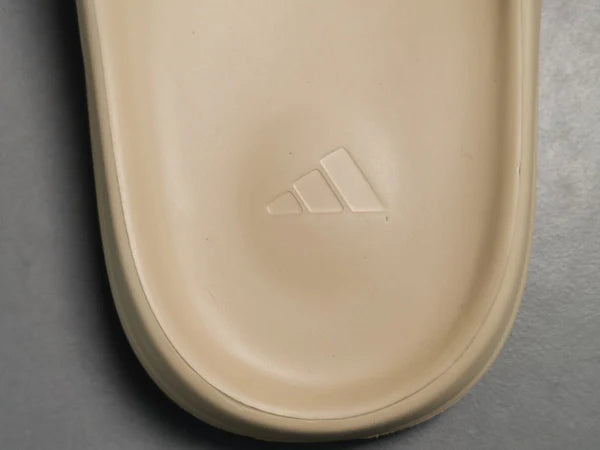 "adidas Yeezy Slide x Pure – neutral-tone slide with soft EVA foam, minimalist design, and ridged outsole for comfort and traction."