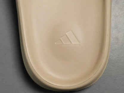 "adidas Yeezy Slide x Pure – neutral-tone slide with soft EVA foam, minimalist design, and ridged outsole for comfort and traction."