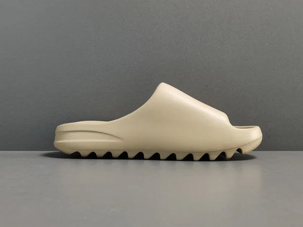 "adidas Yeezy Slide x Pure – neutral-tone slide with soft EVA foam, minimalist design, and ridged outsole for comfort and traction."