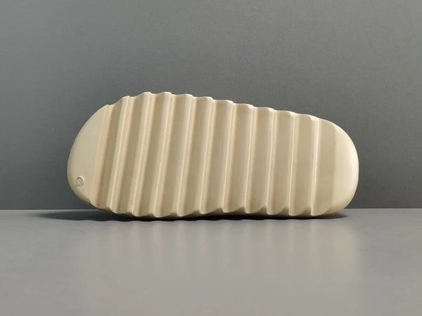 "adidas Yeezy Slide x Pure – neutral-tone slide with soft EVA foam, minimalist design, and ridged outsole for comfort and traction."