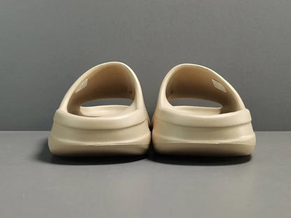 "adidas Yeezy Slide x Pure – neutral-tone slide with soft EVA foam, minimalist design, and ridged outsole for comfort and traction."