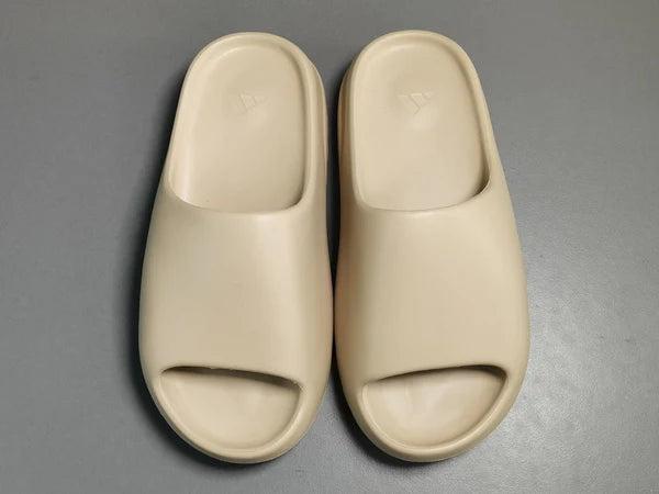 "adidas Yeezy Slide x Pure – neutral-tone slide with soft EVA foam, minimalist design, and ridged outsole for comfort and traction."