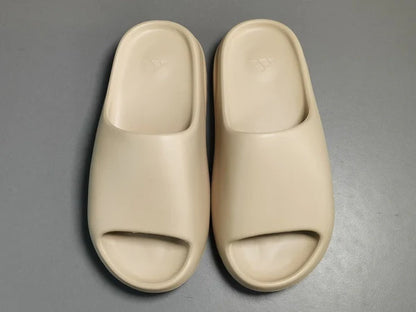 "adidas Yeezy Slide x Pure – neutral-tone slide with soft EVA foam, minimalist design, and ridged outsole for comfort and traction."