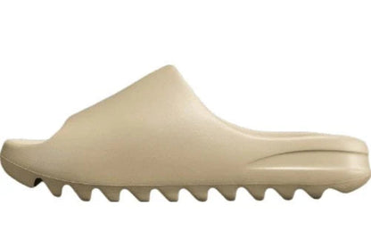 "adidas Yeezy Slide x Pure – neutral-tone slide with soft EVA foam, minimalist design, and ridged outsole for comfort and traction."