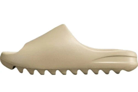 "adidas Yeezy Slide x Pure – neutral-tone slide with soft EVA foam, minimalist design, and ridged outsole for comfort and traction."