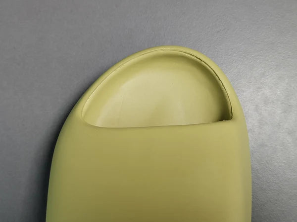 "adidas Yeezy Slide x Resin – earthy green slide with soft EVA foam, minimalist design, and ridged outsole for comfort and traction."