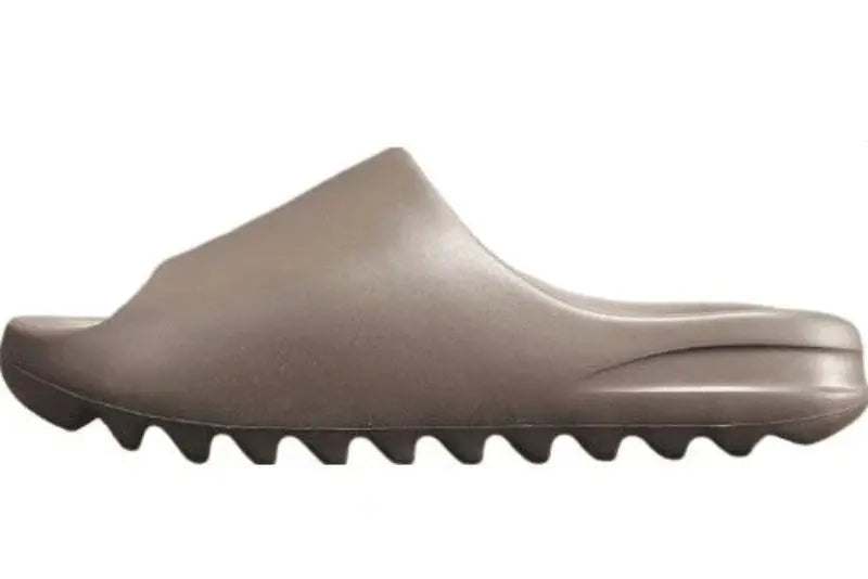 "adidas Yeezy Slide x Soot – dark earth-tone slide with soft EVA foam, minimalist design, and ridged outsole for comfort and traction."