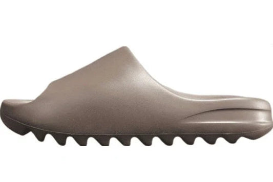 "adidas Yeezy Slide x Soot – dark earth-tone slide with soft EVA foam, minimalist design, and ridged outsole for comfort and traction."