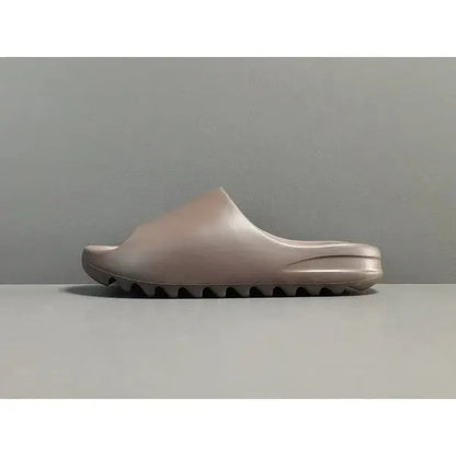 "adidas Yeezy Slide x Soot – dark earth-tone slide with soft EVA foam, minimalist design, and ridged outsole for comfort and traction."