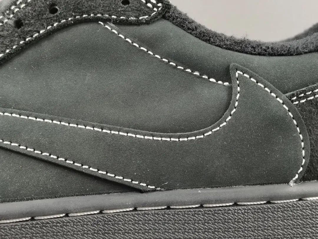 "Jordan 1 Low Travis Scott Phantom with black nubuck, white stitching, and signature reverse Swoosh."
