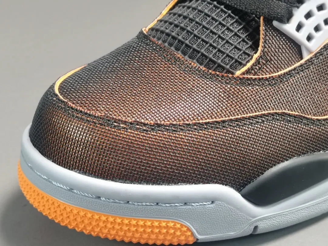 Close-up of a brown athletic shoe with orange sole on a gray background