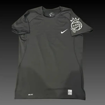 A black Nike athletic t-shirt with a white swoosh on the chest and a white J.League crown logo on the sleeve, displayed against a dark gradient background.