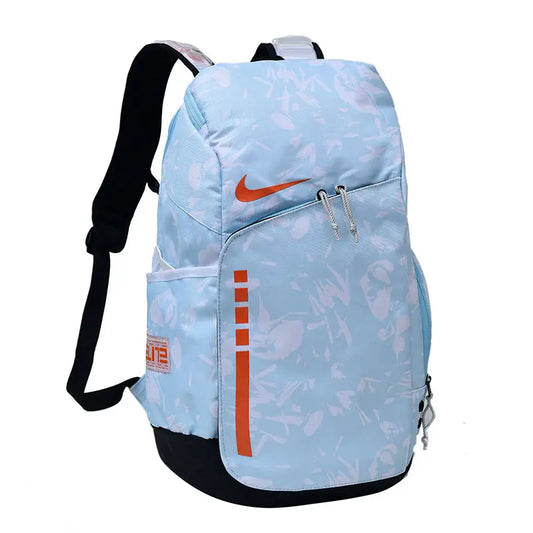 A light blue Nike backpack with a subtle white graffiti-style pattern, orange swoosh logo, and orange vertical stripe detail, shown on a plain white background.