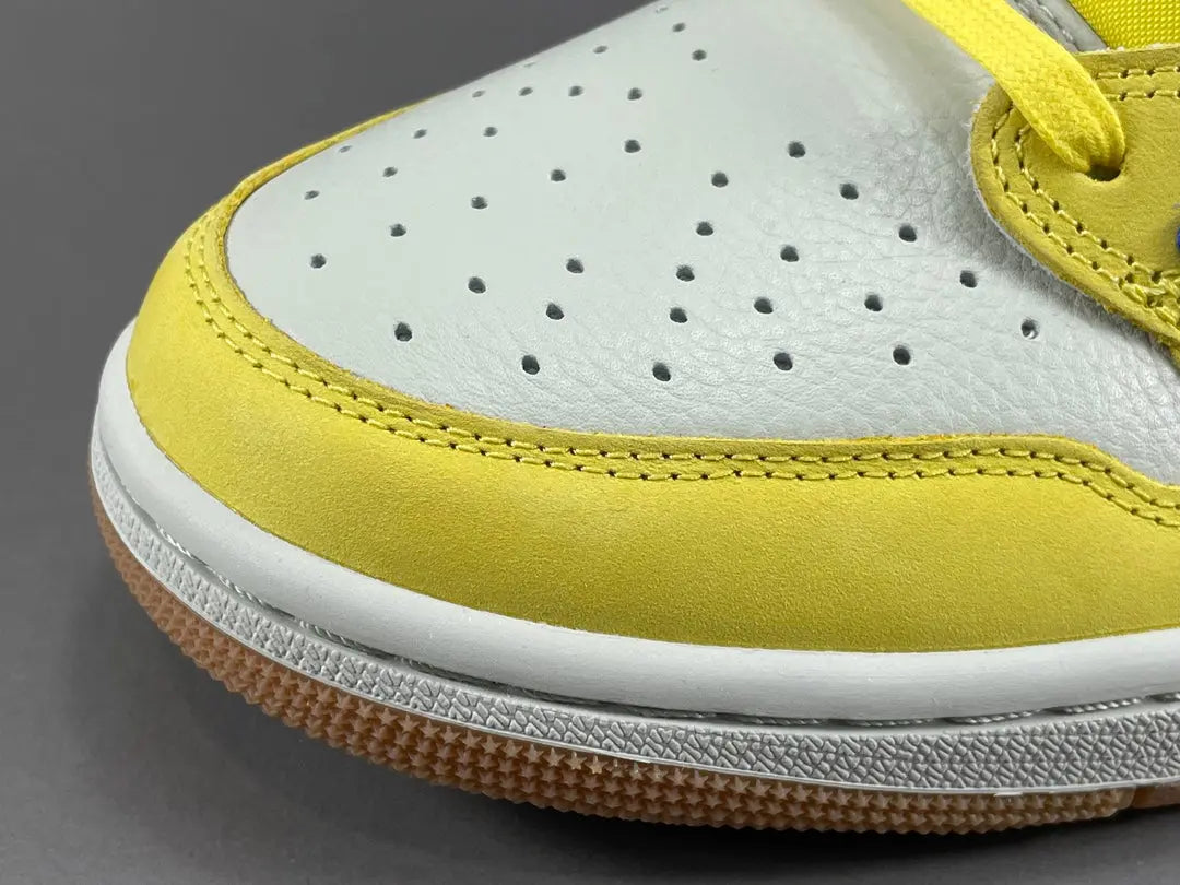 "Jordan 1 Low OG x Canary – low-top sneaker with premium leather upper, bright yellow and white colorway, and classic retro design."